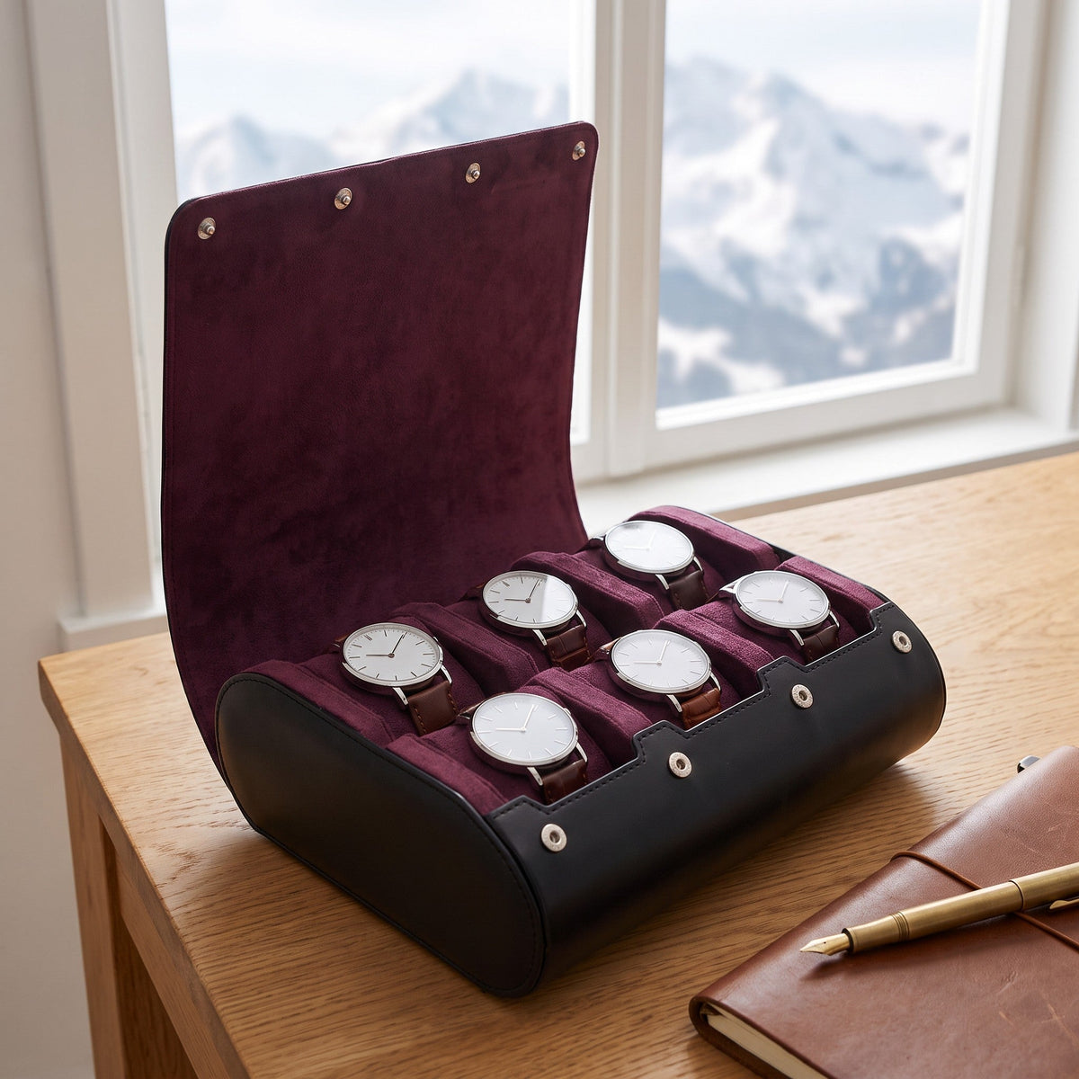 Étui 6 montres Violine en cuir noir, intérieur suédine prune, ouvert sur un bureau en chêne