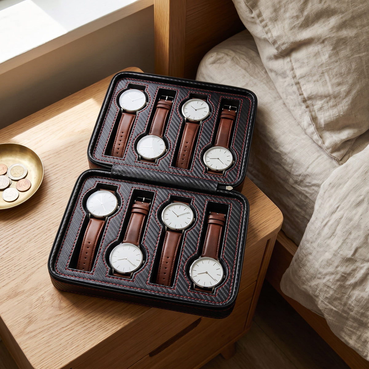 Étui 8 montres Encre Voyage ouvert sur une table de chevet, huit montres tête-bêche