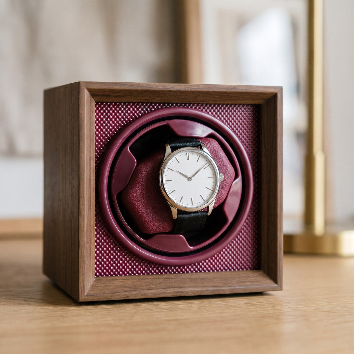 Gros plan sur le coussin bordeaux et le cadre en bois du remontoir 1 montre Grenat