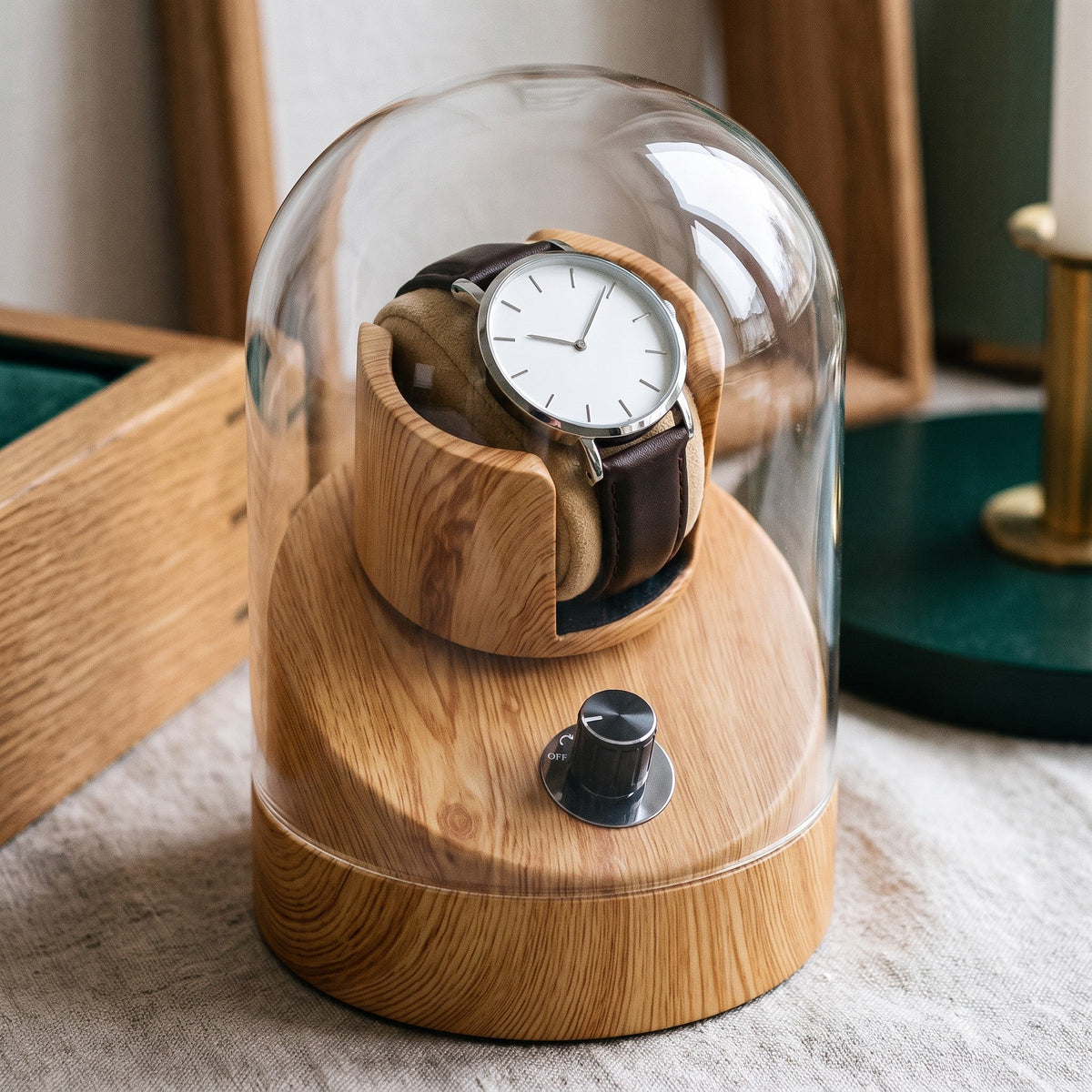 Gros plan sur la cloche en verre et le socle en pin du remontoir Perlage 1 montre