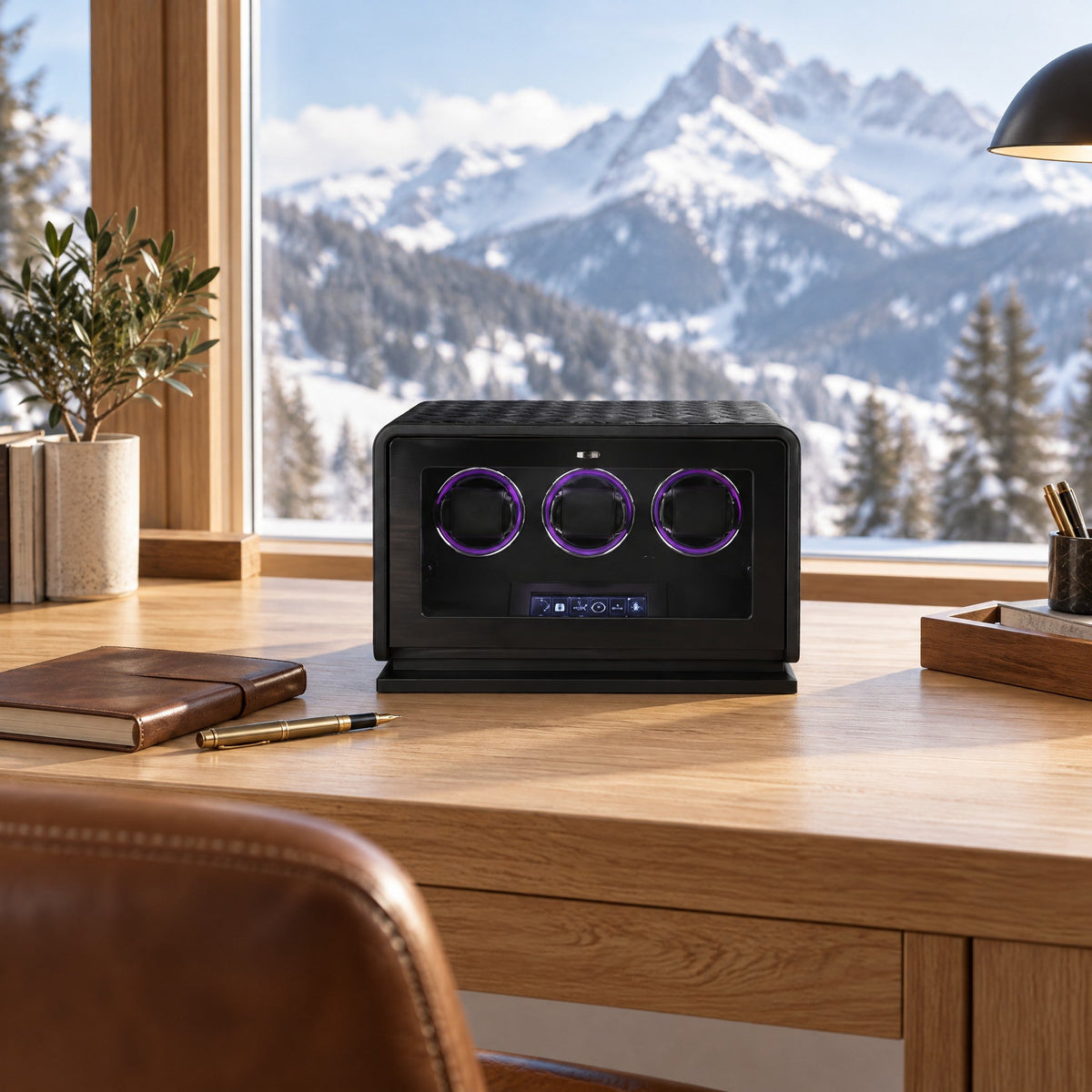 Remontoir 3 montres Méridien noir en cuir matelassé, porte vitrée fermée, sur un bureau en chêne face à la montagne