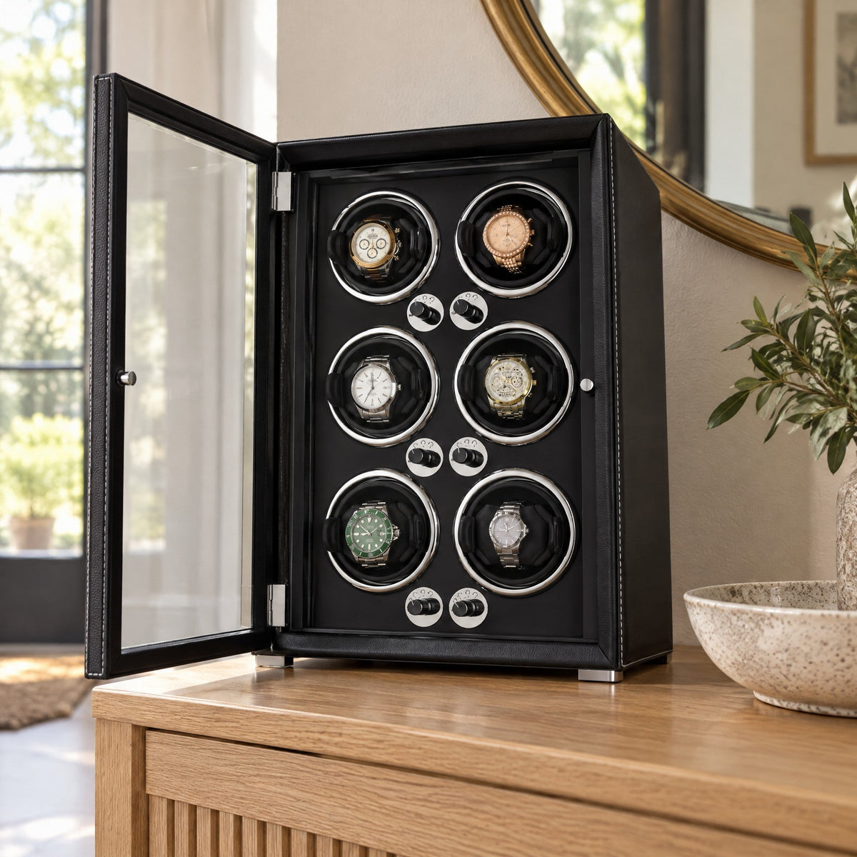 Remontoir 6 montres Balancier noir, porte vitrée ouverte, sur une console d'entrée
